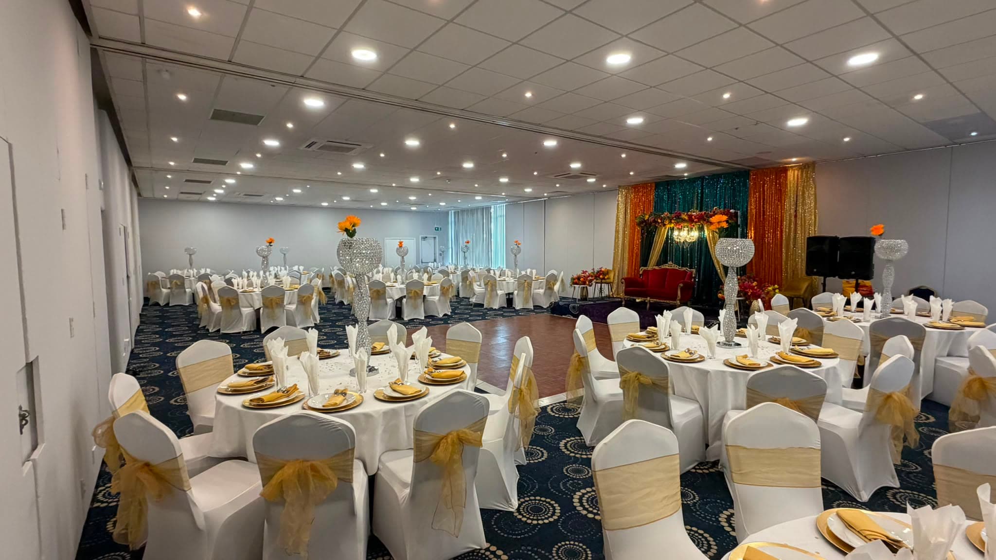 The Bedfordshire Suite at full length, dressed for two hundred guests with the stage on the right.