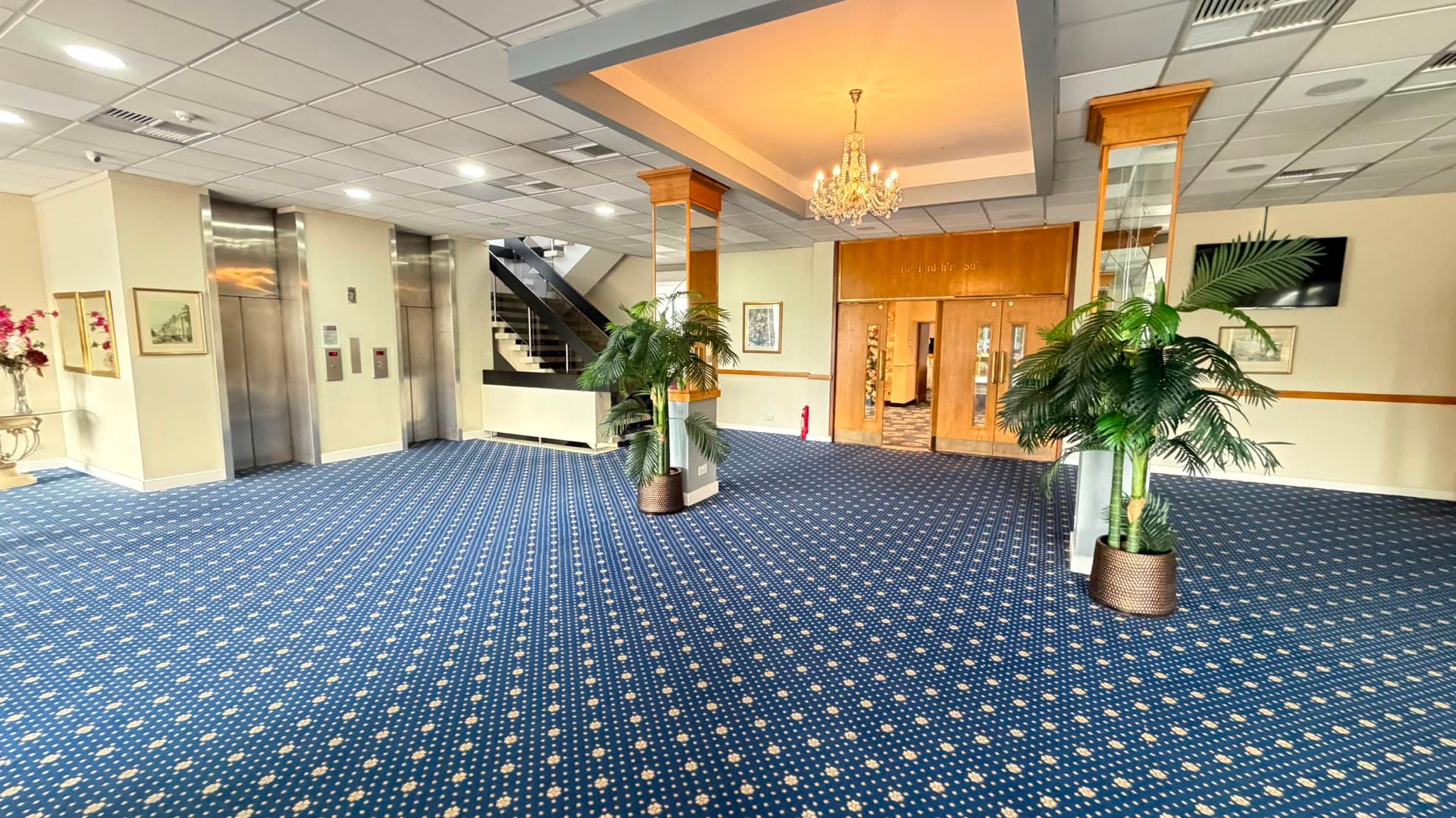 The hotel's ground-floor lobby: chandelier, lifts and the double doors into the Bedfordshire Suite.