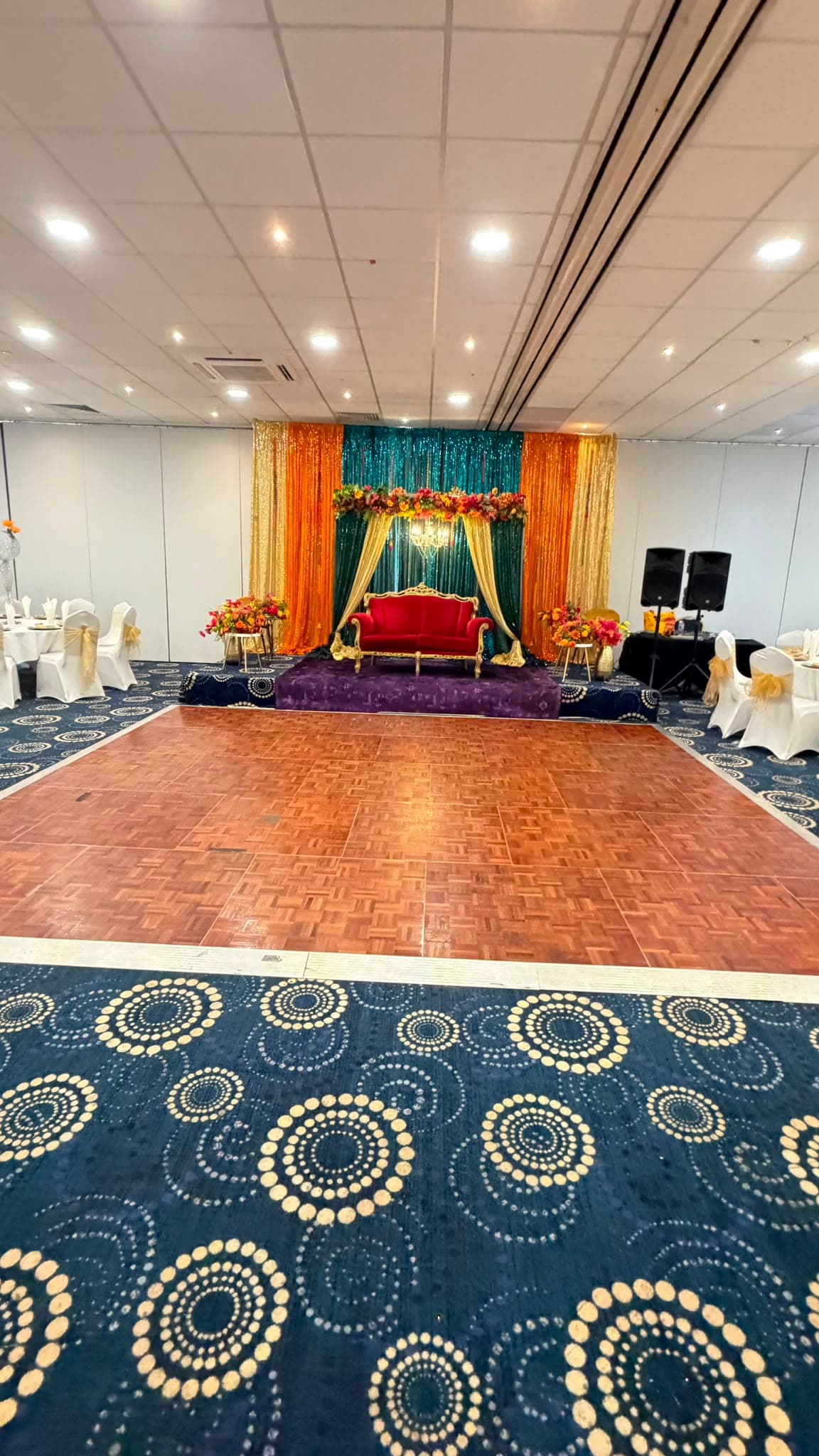 The Bedfordshire Suite looking down the dance floor towards the lit wedding stage.